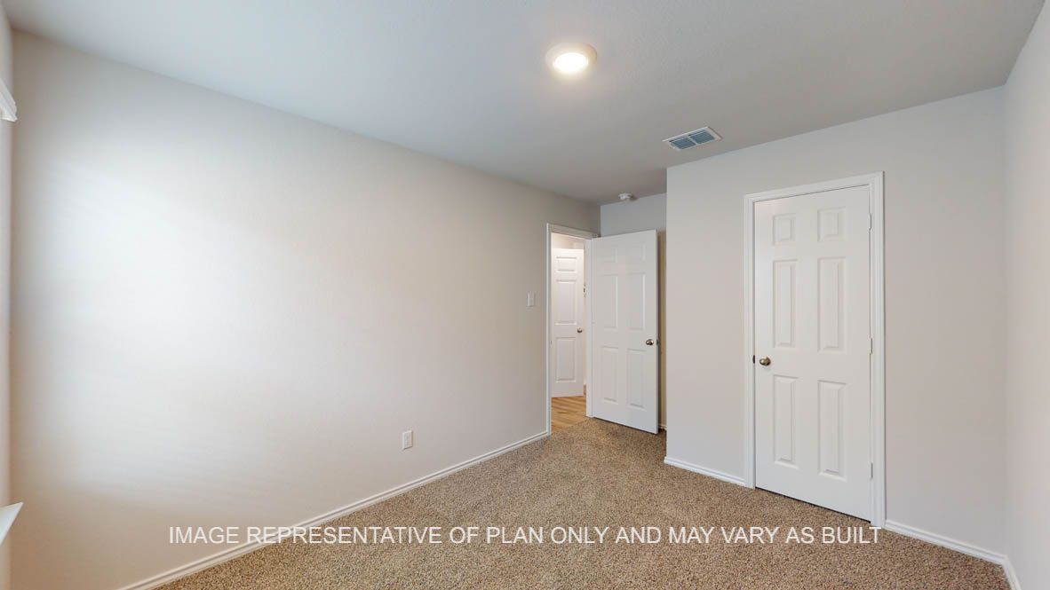 Abbot secondary bedroom with carpet flooring and view of hallway.
