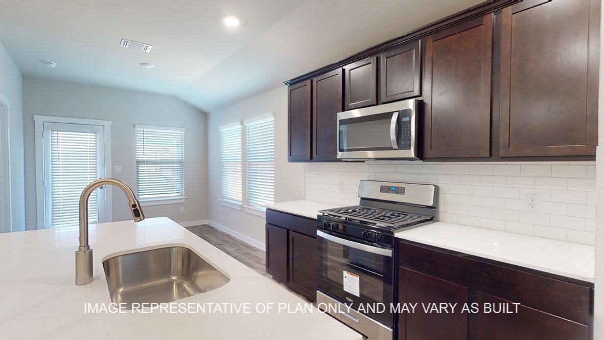 Baxtor kitchen with dark cabinets and white quartz countertops.