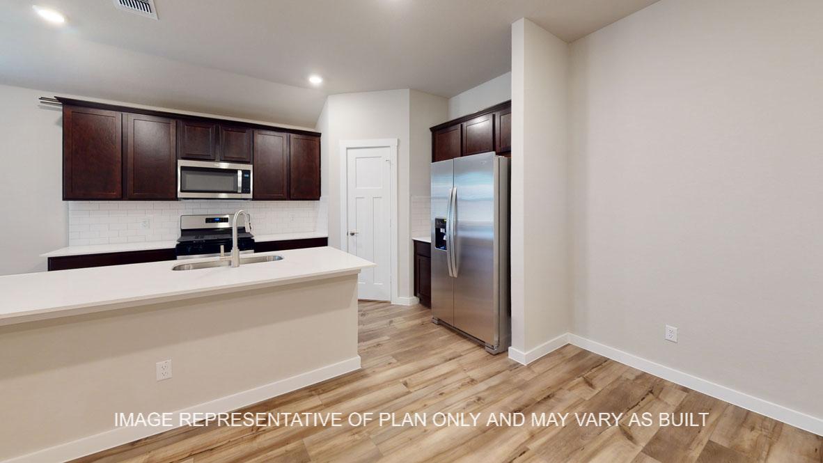 Baxtor kitchen with dark cabinet, white quartz countertops and vinyl plank flooring.