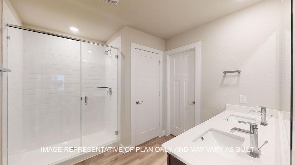 Baxtor primary bathroom with clear shower glass enclosure and white tile surround in shower.
