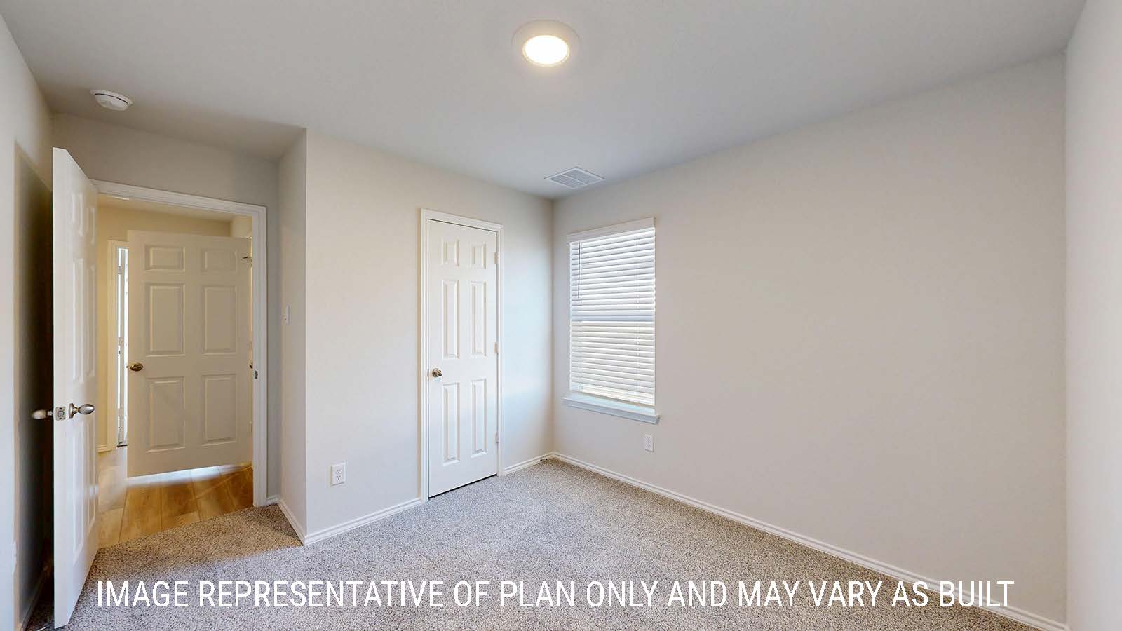 Caden secondary bedroom with carpeted flooring and view of hallway.
