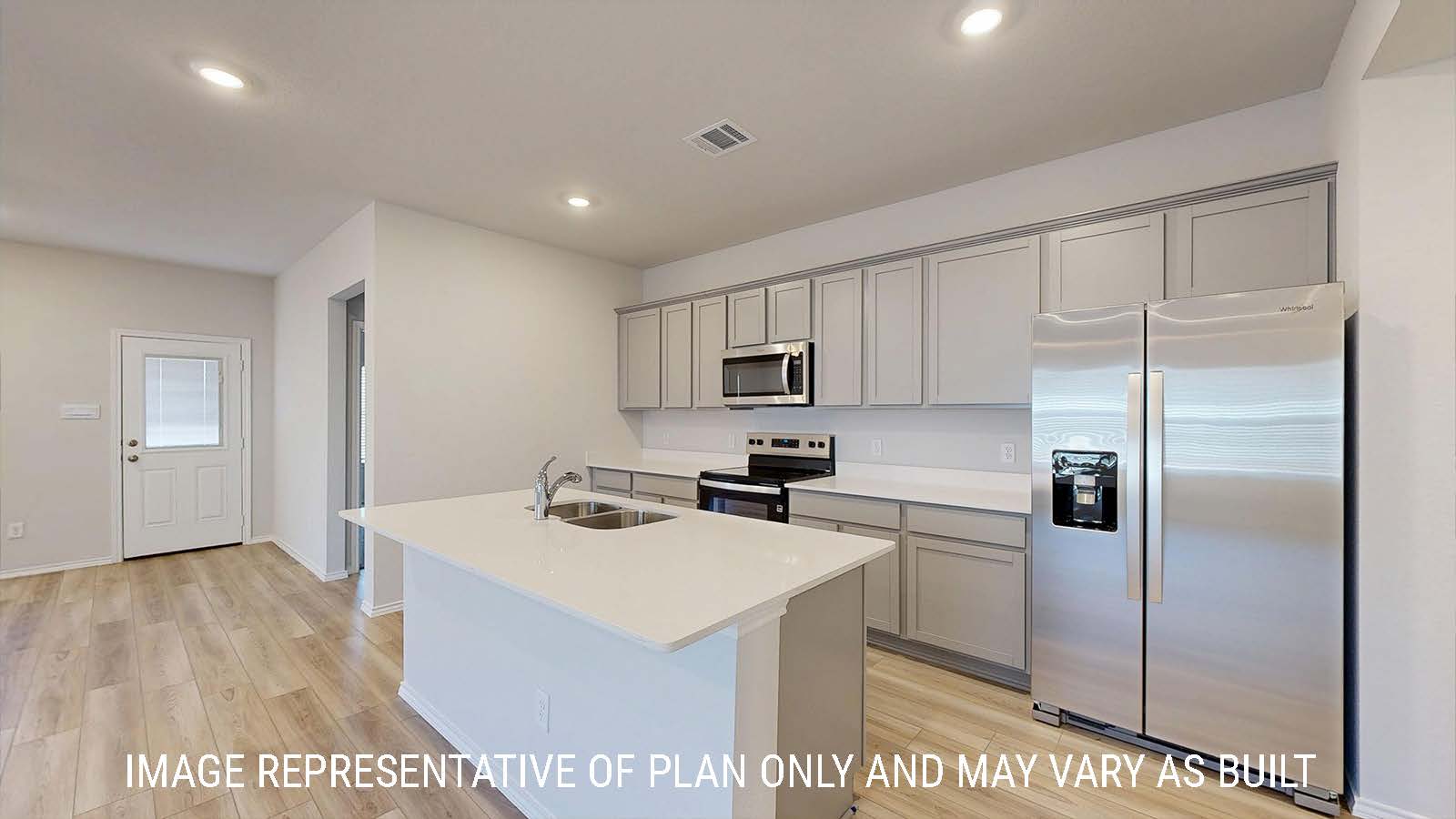 Caden kitchen light cabinets and light countertops with view of living room.