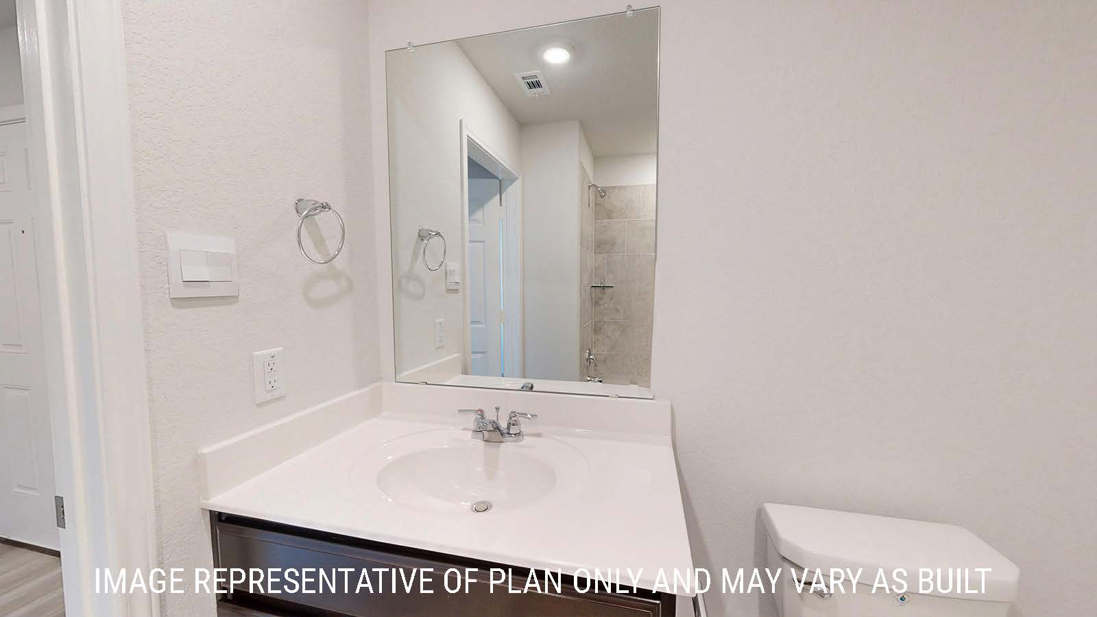 Caden secondary bathroom with vanity sink and dark cabinets.