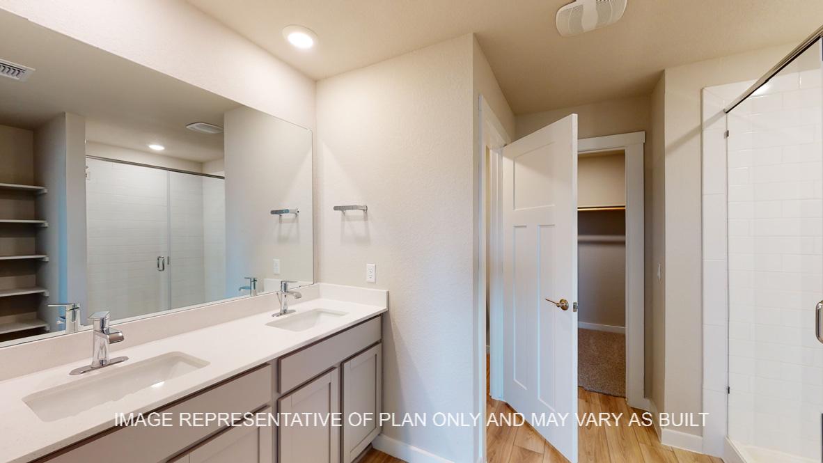 Easton primary bath with gray cabinets and white countertops.