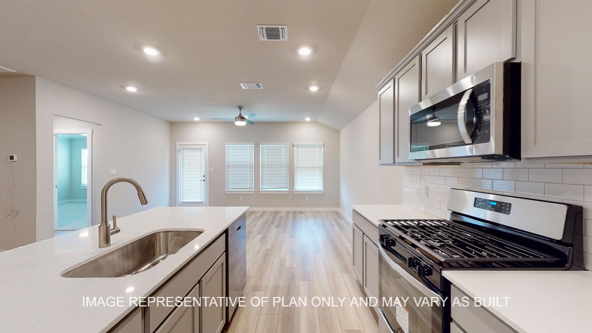 Easton kitchen with quartz kitchen island, gray cabinets and vinyl plank flooring.