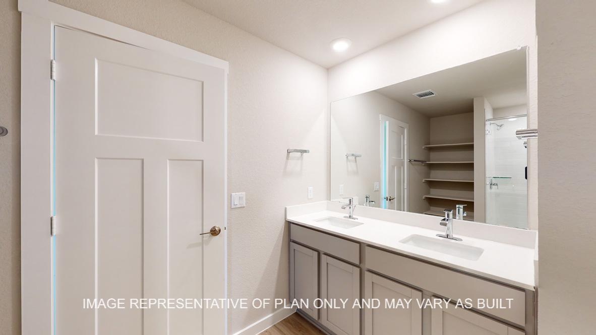 Easton primary bath with gray cabinets and white countertops.