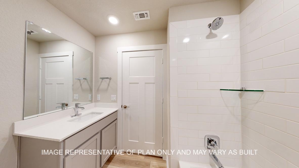 Easton secondary bath with gray cabinets and white countertops.
