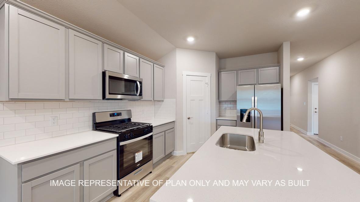 Easton kitchen with quartz kitchen island, gray cabinets and vinyl plank flooring.