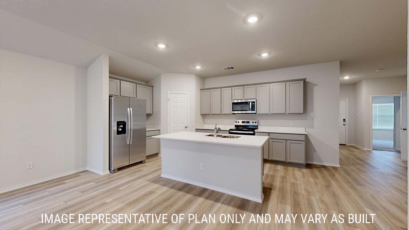 Gaven kitchen with light cabinets and white countertops with view of front hallway.