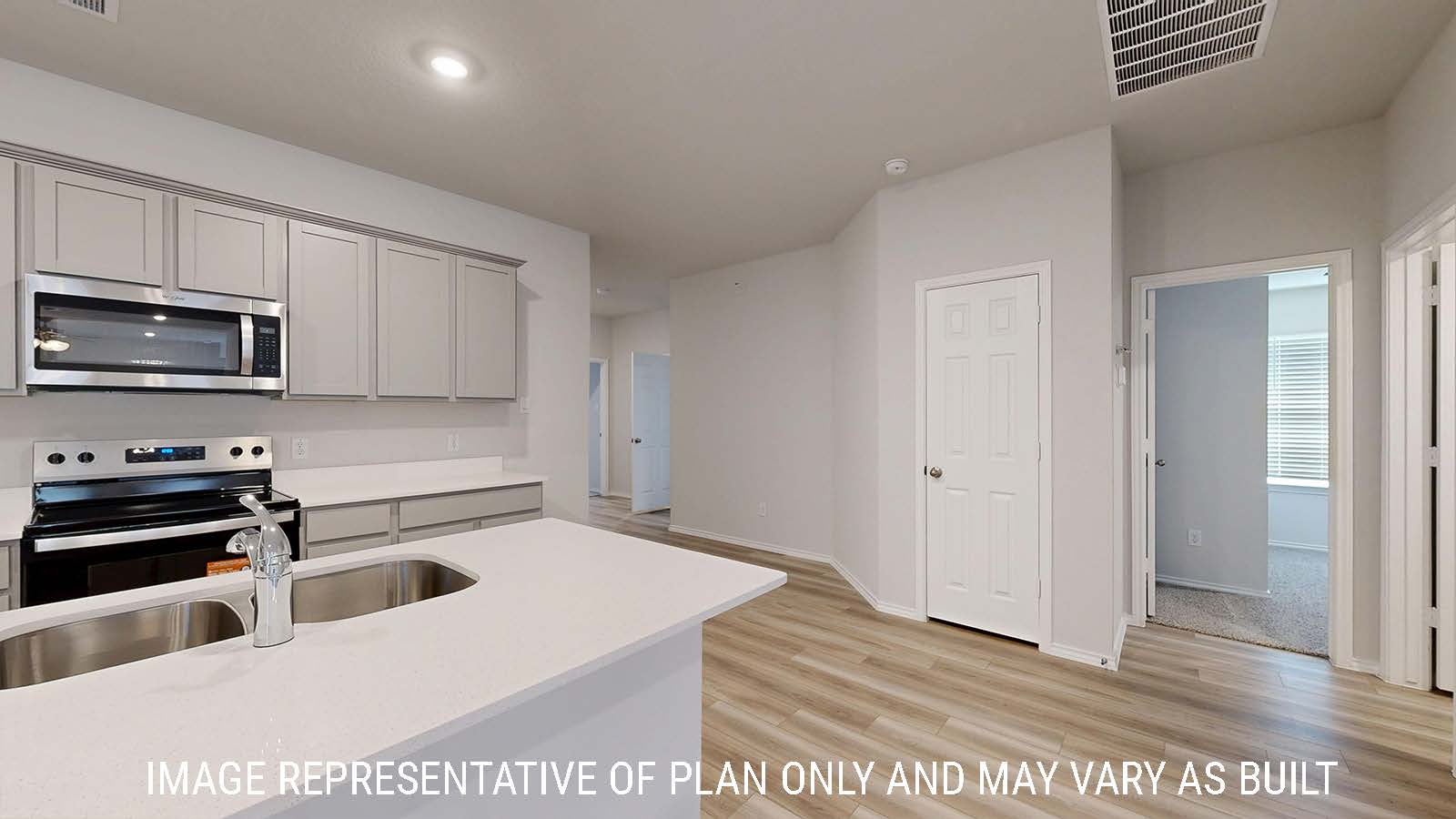 Gaven kitchen with light cabinets and white countertops with view of front hallway.