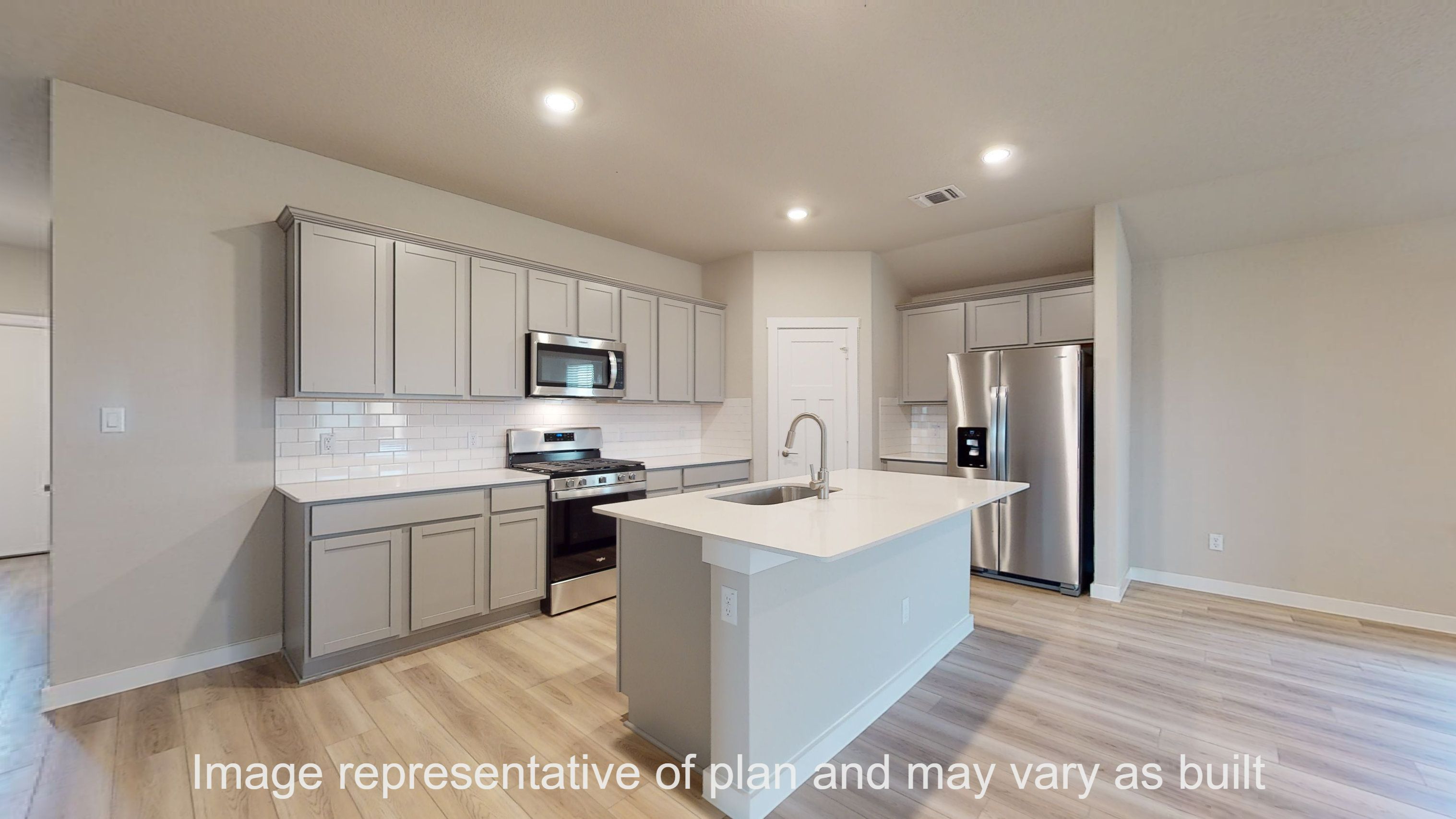 Gaven kitchen with gray cabinets, quartz countertops and stainless appliances.