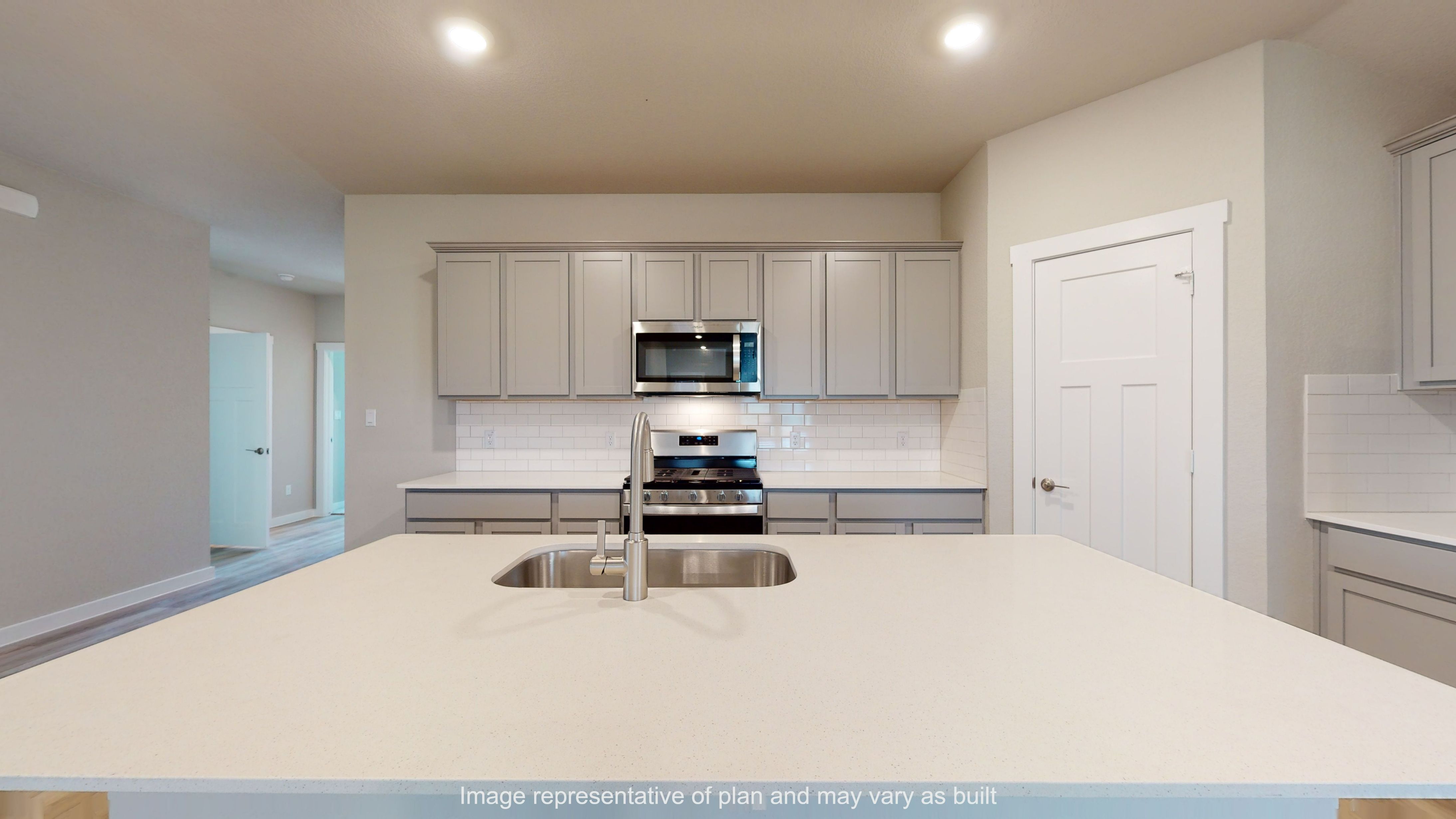 Gaven kitchen with large quartz island and gray cabinets.