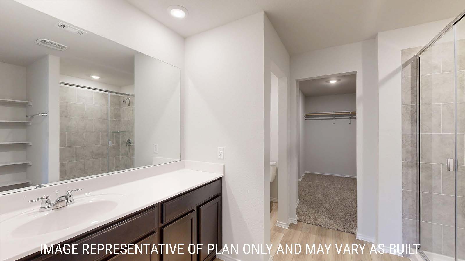 Harris primary bathroom with vanity sink and view of primary walk-in closet.