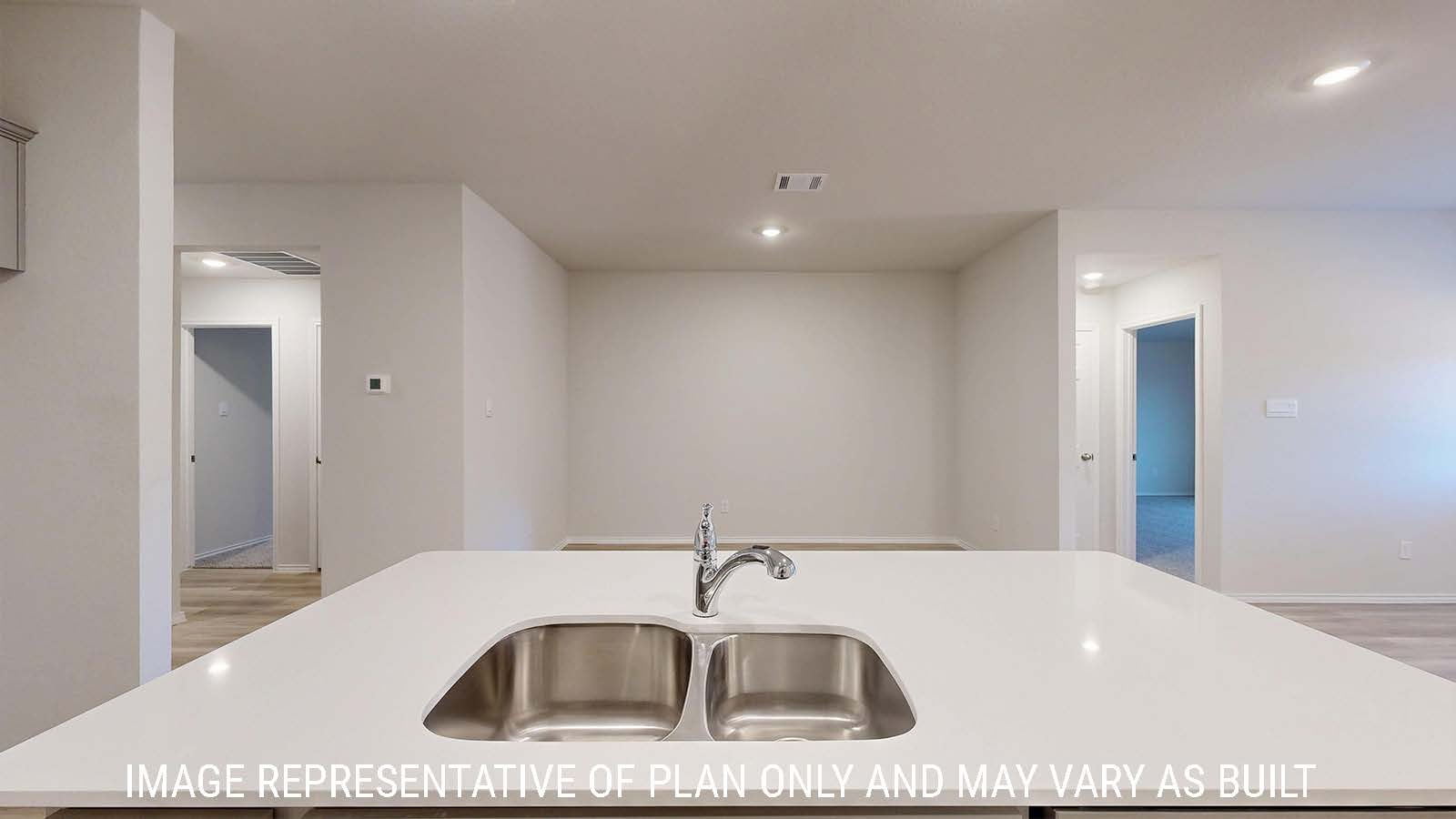 Harris kitchen with light cabinets and light countertops with view of dining room.