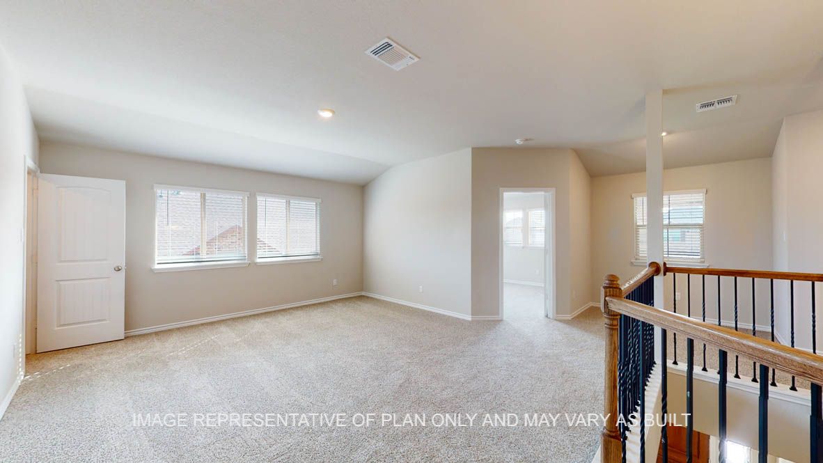 Kiawa large game room with carpet flooring and view to secondary bedroom.