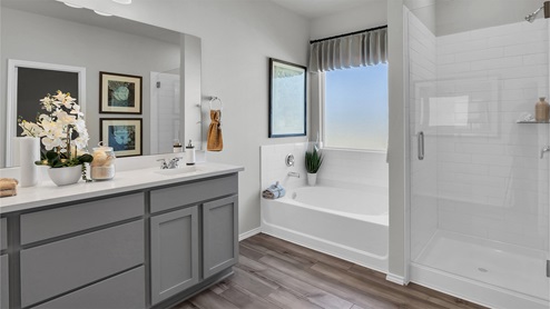 Turnbo Ranch Traditions primary bathroom with walk-in shower and tub.