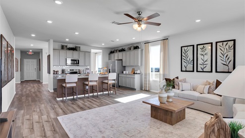 Turnbo Ranch Traditions model home living room with view of the kitchen.