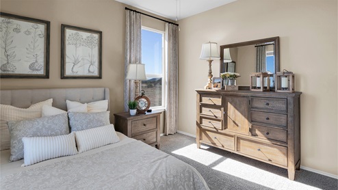 Turnbo Ranch Traditions primary bedroom with queen bed and carpet flooring.