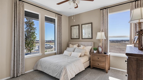 Turnbo Ranch Traditions primary bedroom with queen bed and carpet flooring.