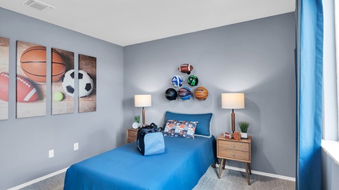 Oak Ridge model home secondary bedroom with twin bed and accent decor.