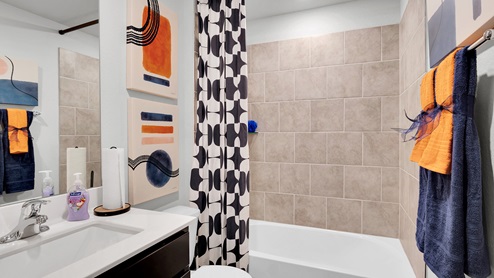 Oak Ridge model home secondary bathroom with tub and shower combination and ceramic tile surround.