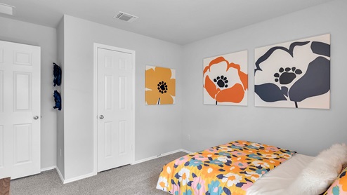 Oak Ridge model home secondary bedroom with carpet and furnished.
