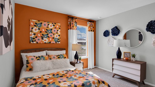 Oak Ridge model home secondary bedroom with carpet and furnished.