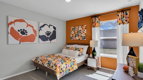 Oak Ridge model home secondary bedroom with carpet and furnished.