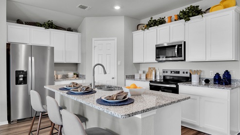 Oak Ridge model home kitchen with white cabinets and granite countertops.