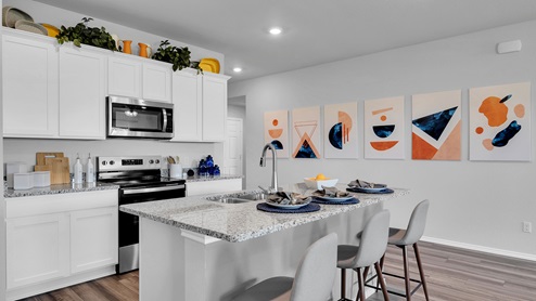 Oak Ridge model home kitchen with white cabinets and granite countertops.