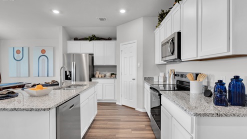 Oak Ridge model home kitchen with white cabinets and granite countertops.