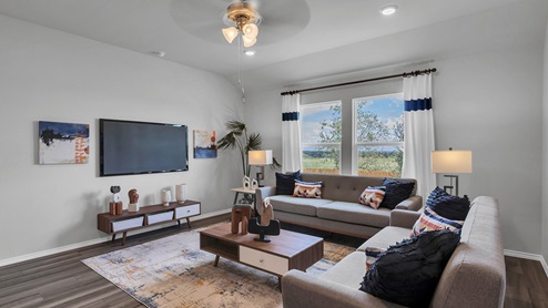 Oak Ridge model home living room with furniture and windows offering natural lighting.