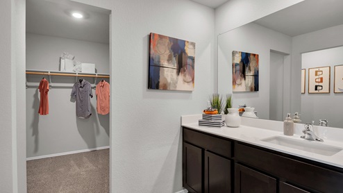 Oak Ridge model home primary bath with dark cabinets and white countertops.