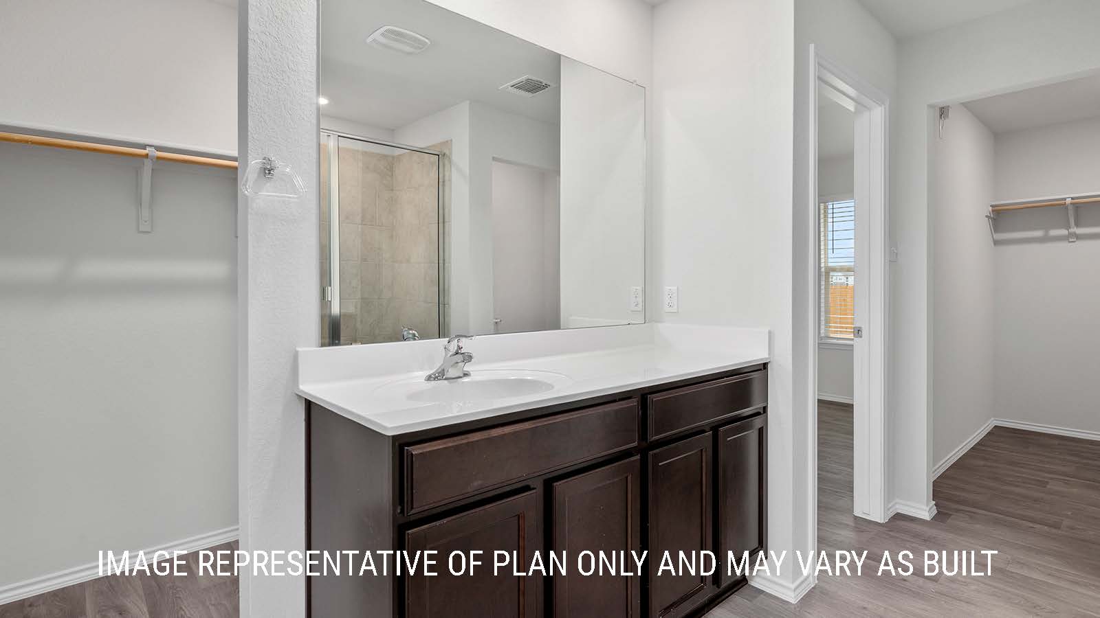 Camden primary bathroom with single vanity and view of the primary closet.