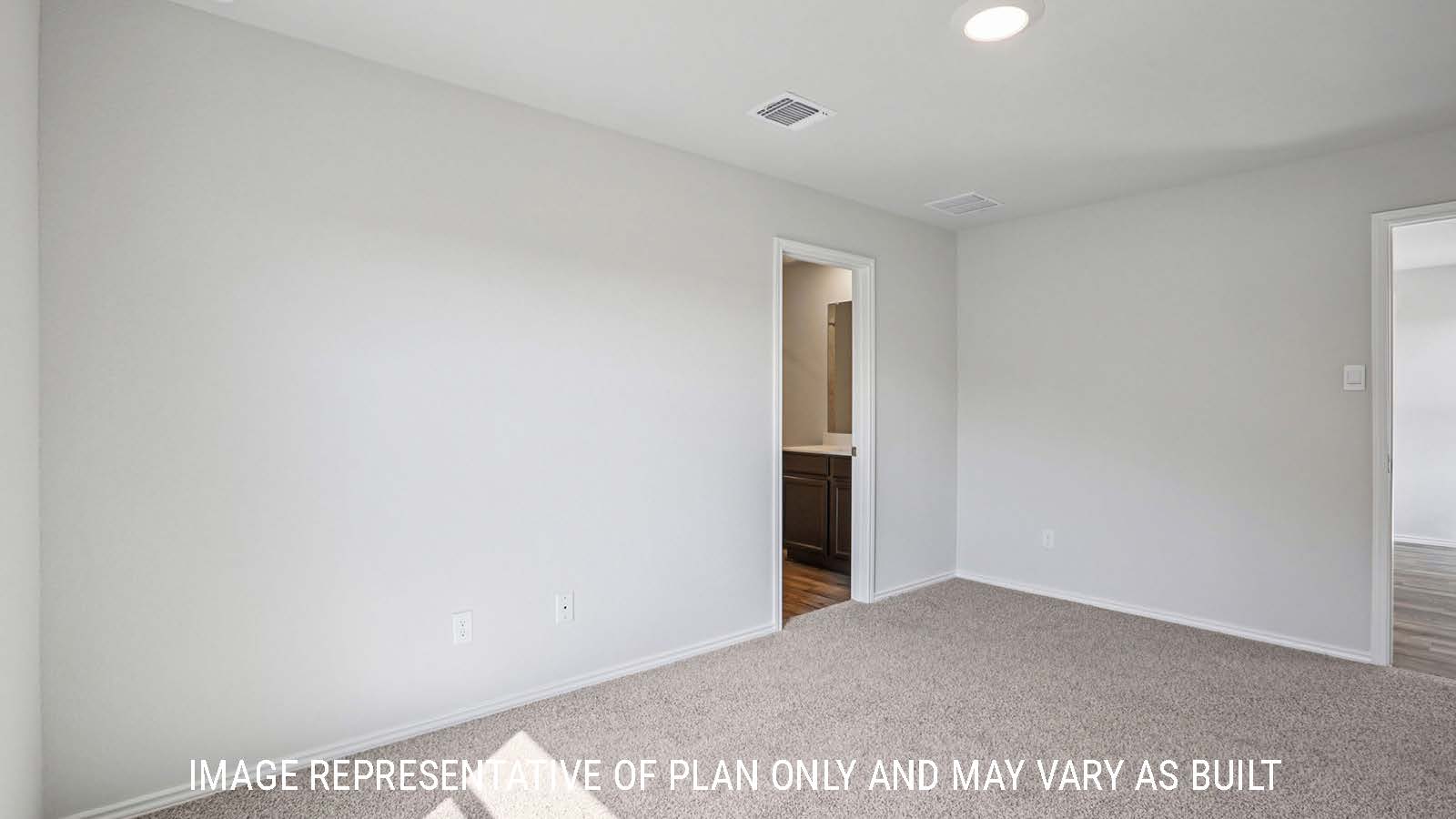 Atlanta primary bedroom with carpeted flooring and view of primary bathroom.