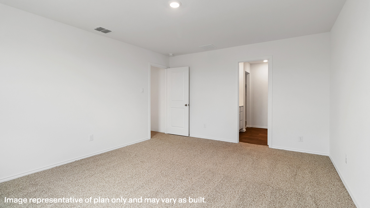 Davis primary bedroom with carpeted flooring and view of primary bathroom.