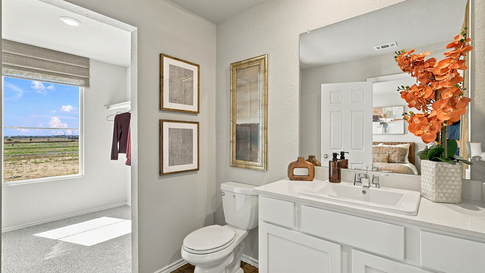 Pepper Creek Crossing model primary bathroom with vanity sink and view of primary bedroom.