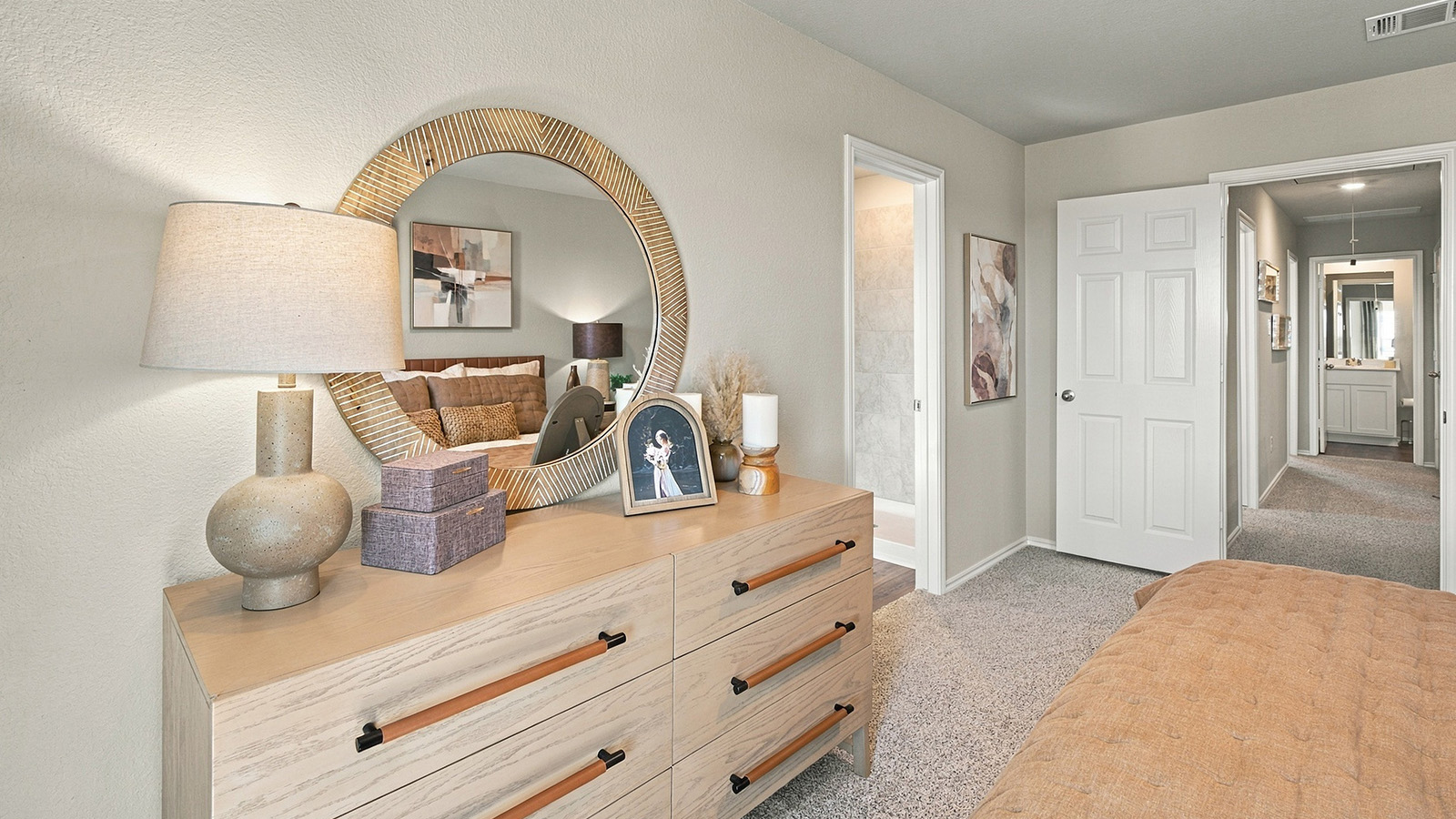Pepper Creek Crossing model primary bedroom with carpeted flooring and view of primary bathroom.