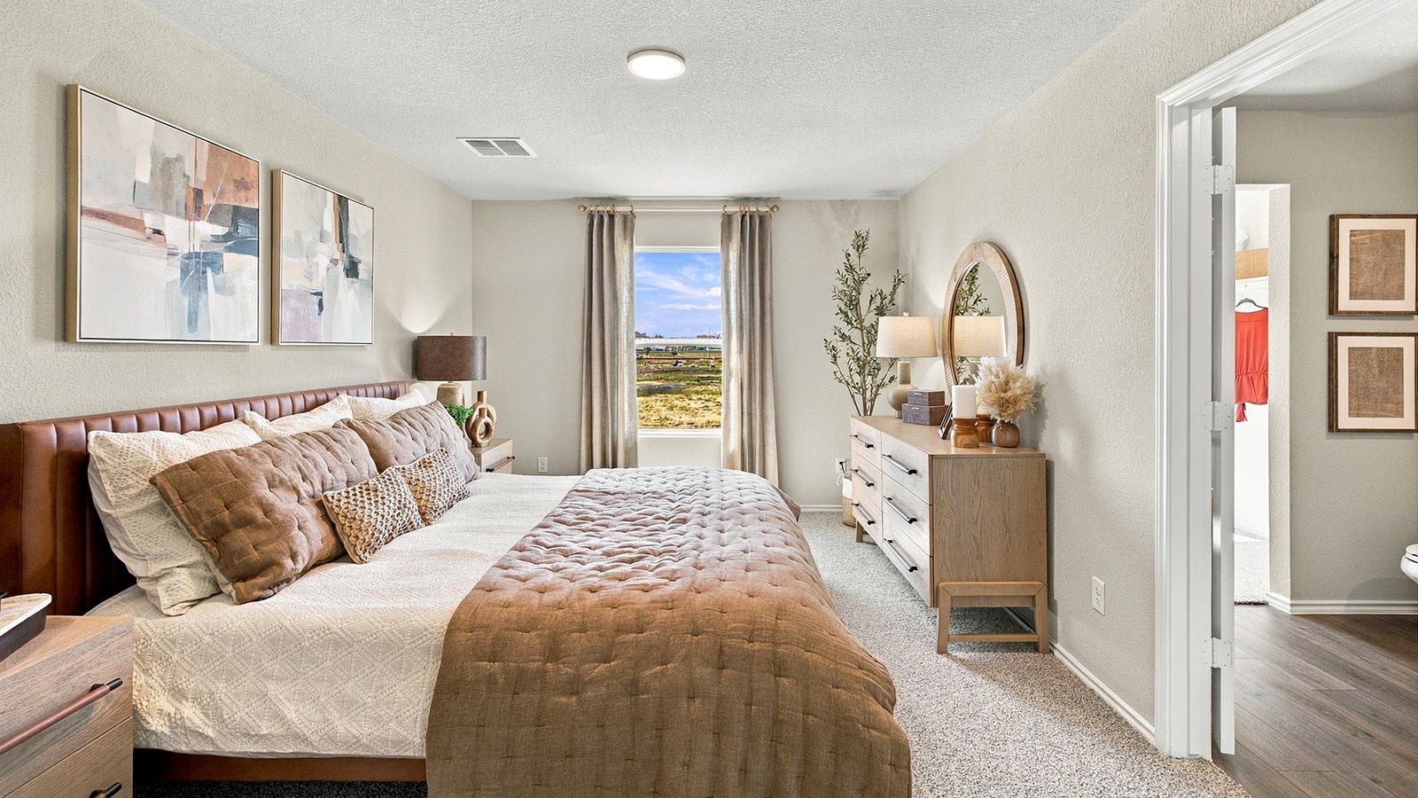 Pepper Creek Crossing model primary bedroom with carpeted flooring and window for natural lighting.