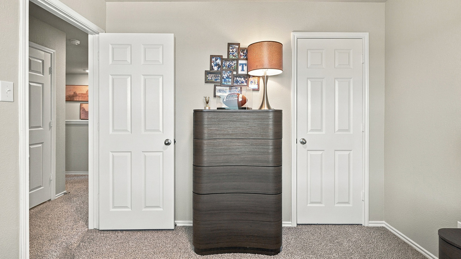 Pepper Creek Crossing model secondary bedroom with carpeted flooring and view of hallway.