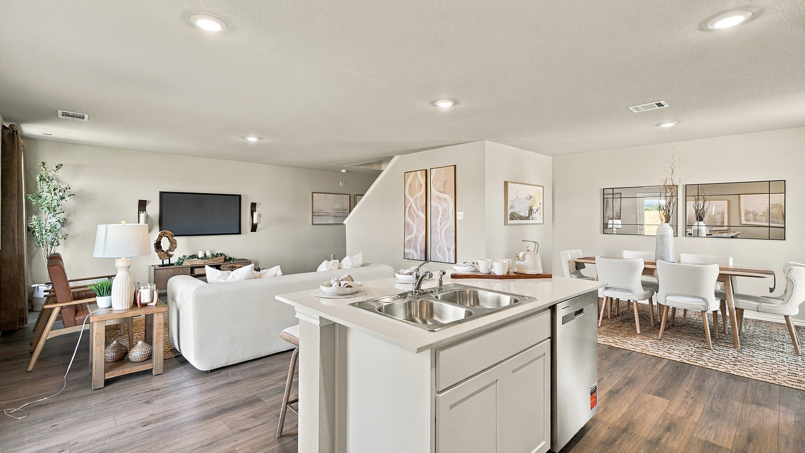 Pepper Creek Crossing model kitchen with kitchen island and view of open concept living room and dining room.