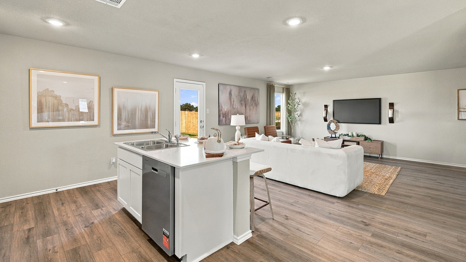 Pepper Creek Crossing model kitchen with kitchen island with view of open concept living room.