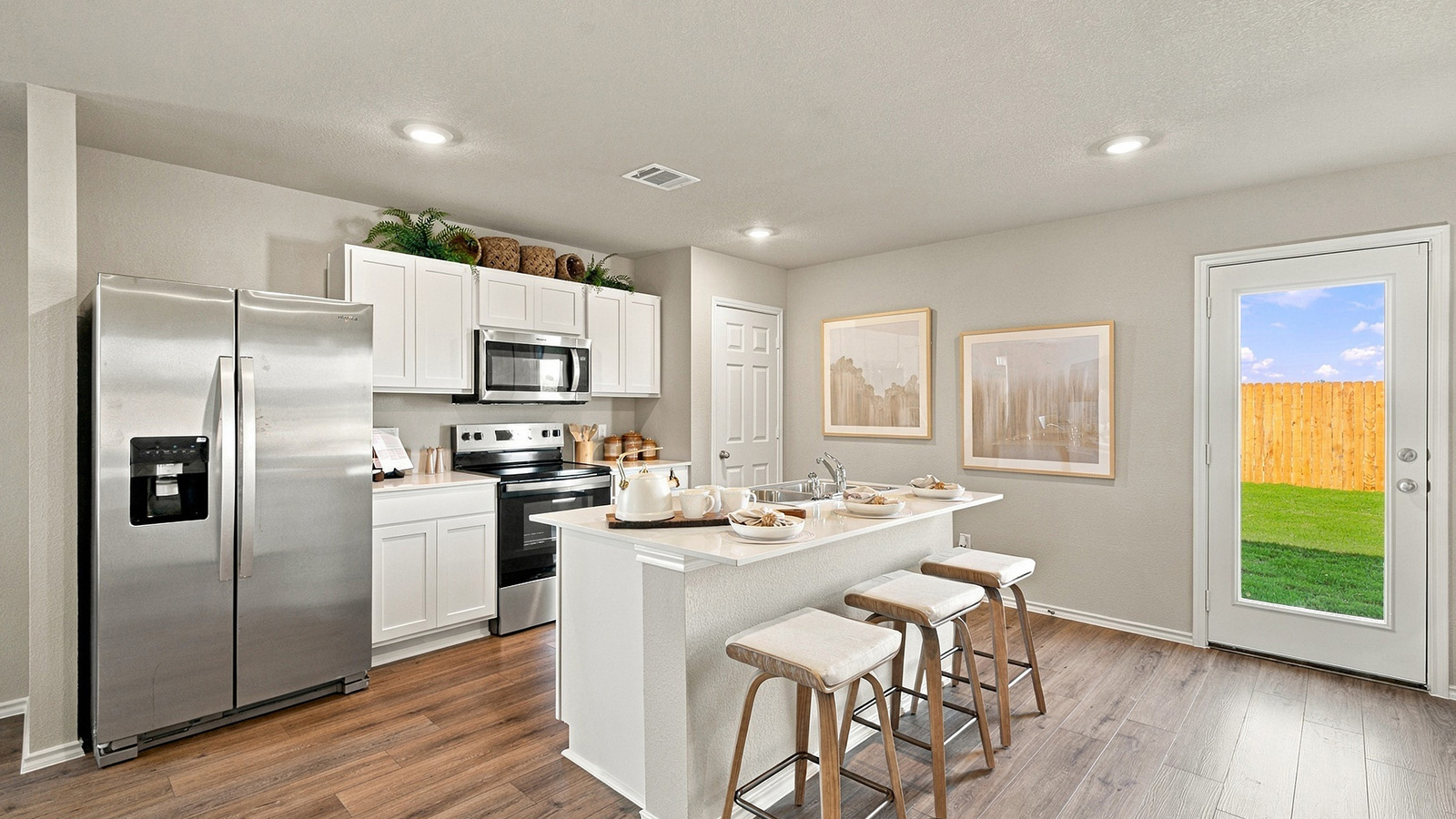 Pepper Creek Crossing model kitchen with kitchen island with light cabinets and window for natural lighting.