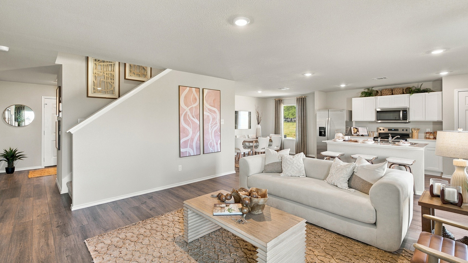 Pepper Creek Crossing model living room with view of stairs and open concept kitchen.