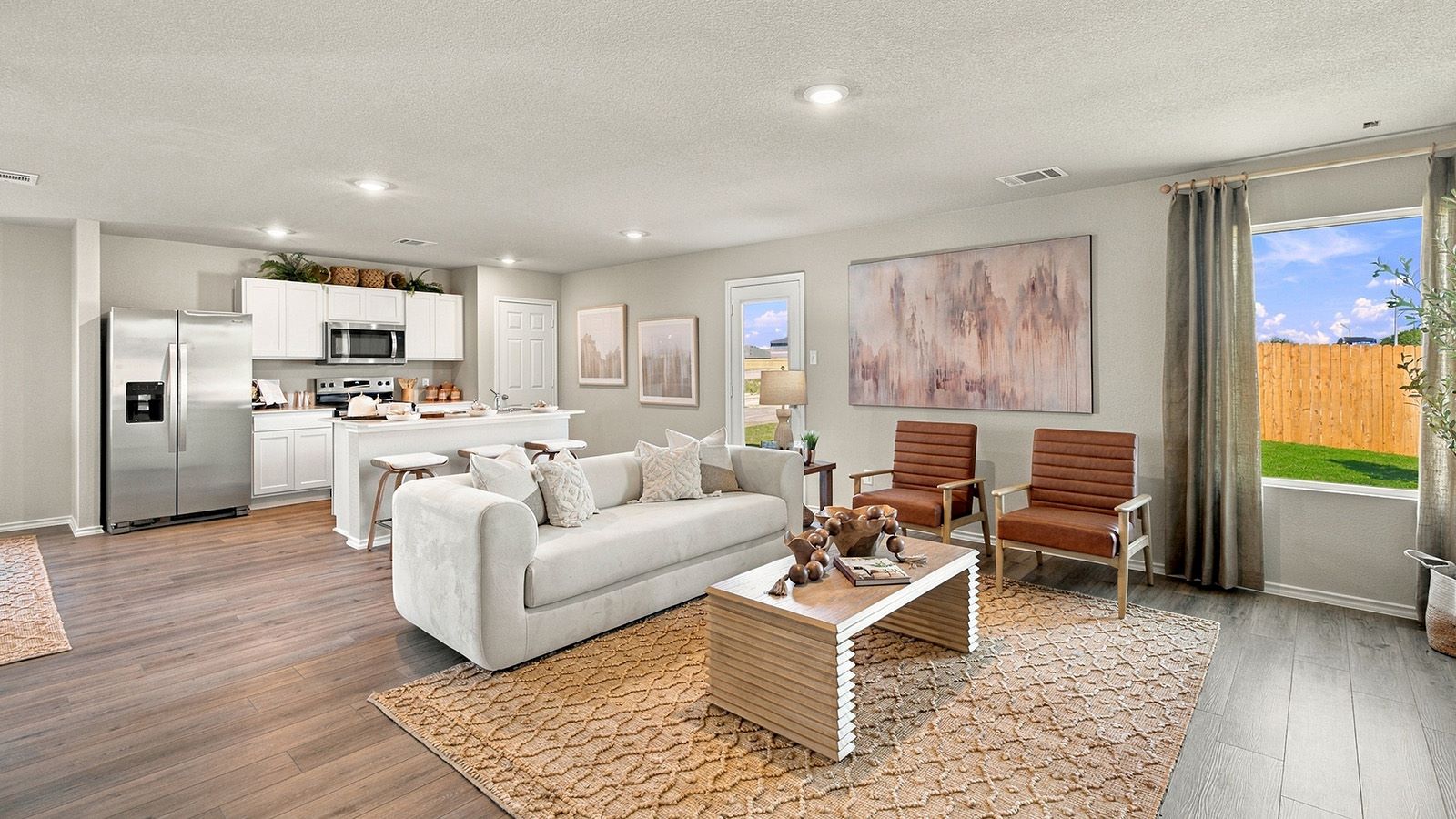 Pepper Creek Crossing model living room with view of open concept kitchen and window for natural lighting.