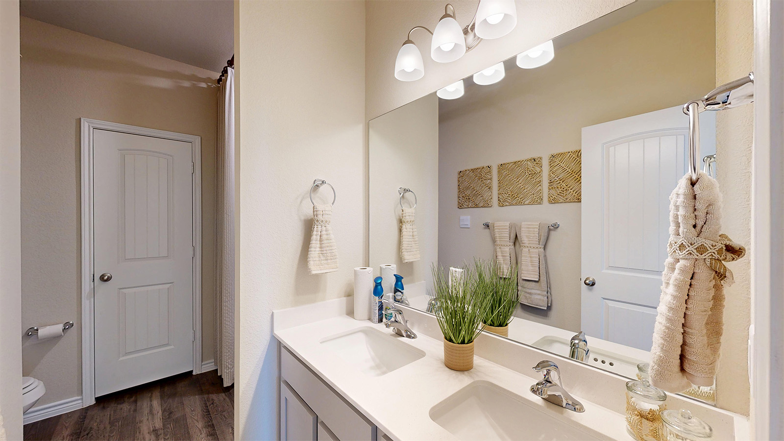 Newburgh primary bathroom with double vanity sink and light cabinets and granite countertops.