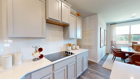 Newburgh kitchen with light cabinets and granite countertops with view of dining room.