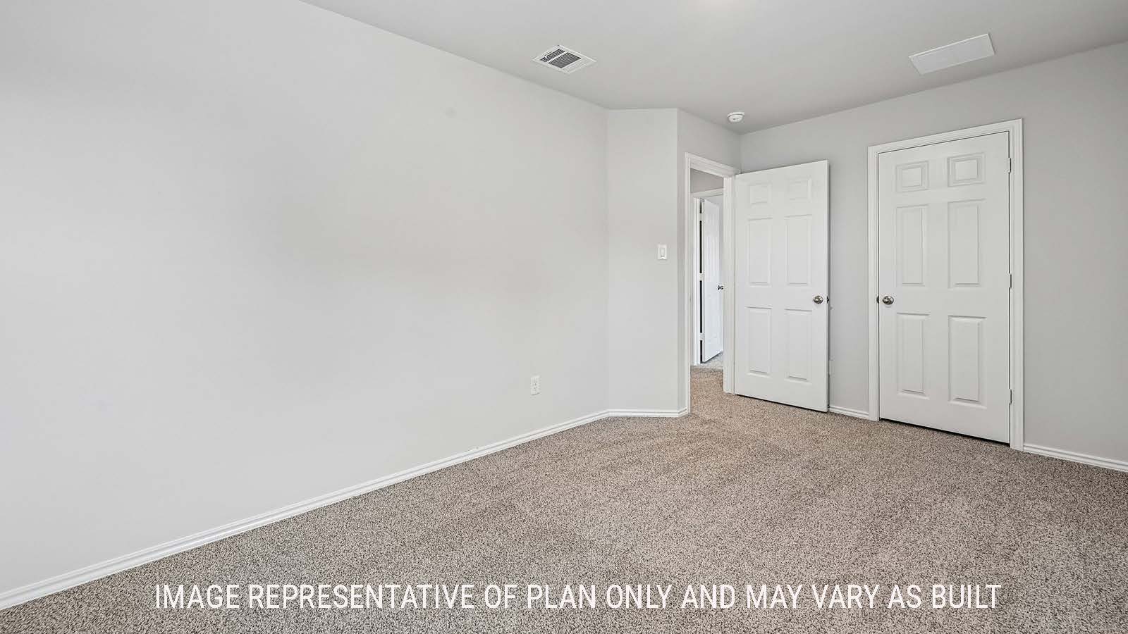 Madison secondary bedroom with carpeted flooring and view of hallway.