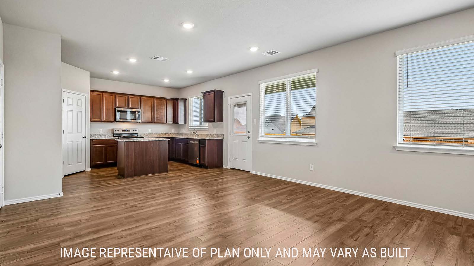 Prosper dining room with view of open concept kitchen and windows for natural lighting.