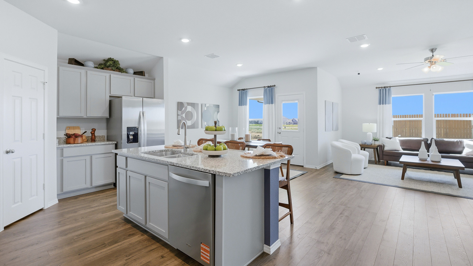 Eagles Landing Model Home kitchen with kitchen island with granite countertops and view of open concept dining room and living room.